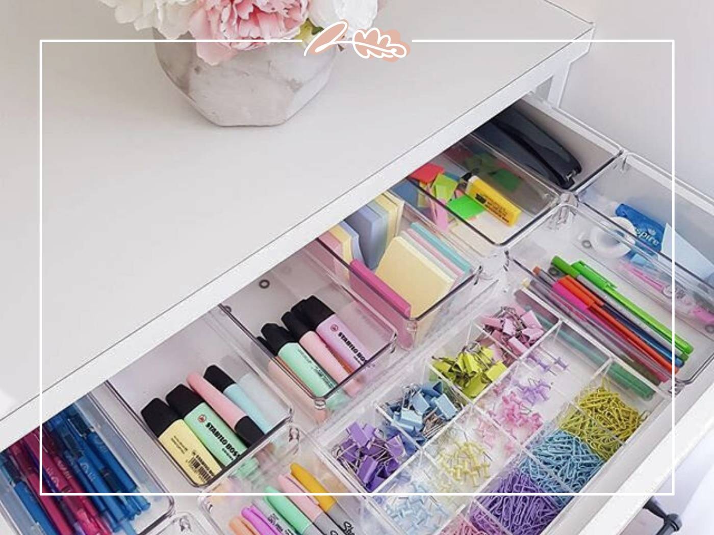 A neatly organised drawer filled with colourful stationery and supplies on a white desk with pink flowers on top - Fabulous Flowers and Gifts