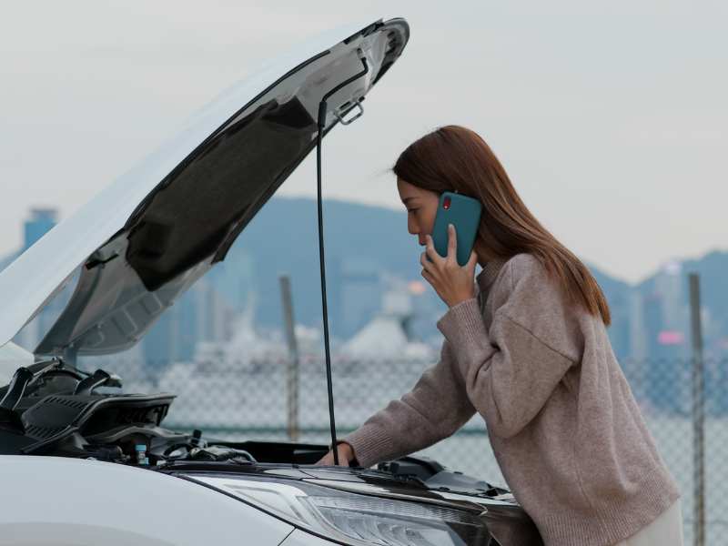 Image of a person on the phone calling for help after a truck highway accident.