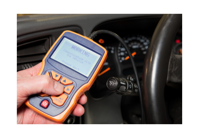 A mechanic using an OBD2 scanner to reset the ABS light