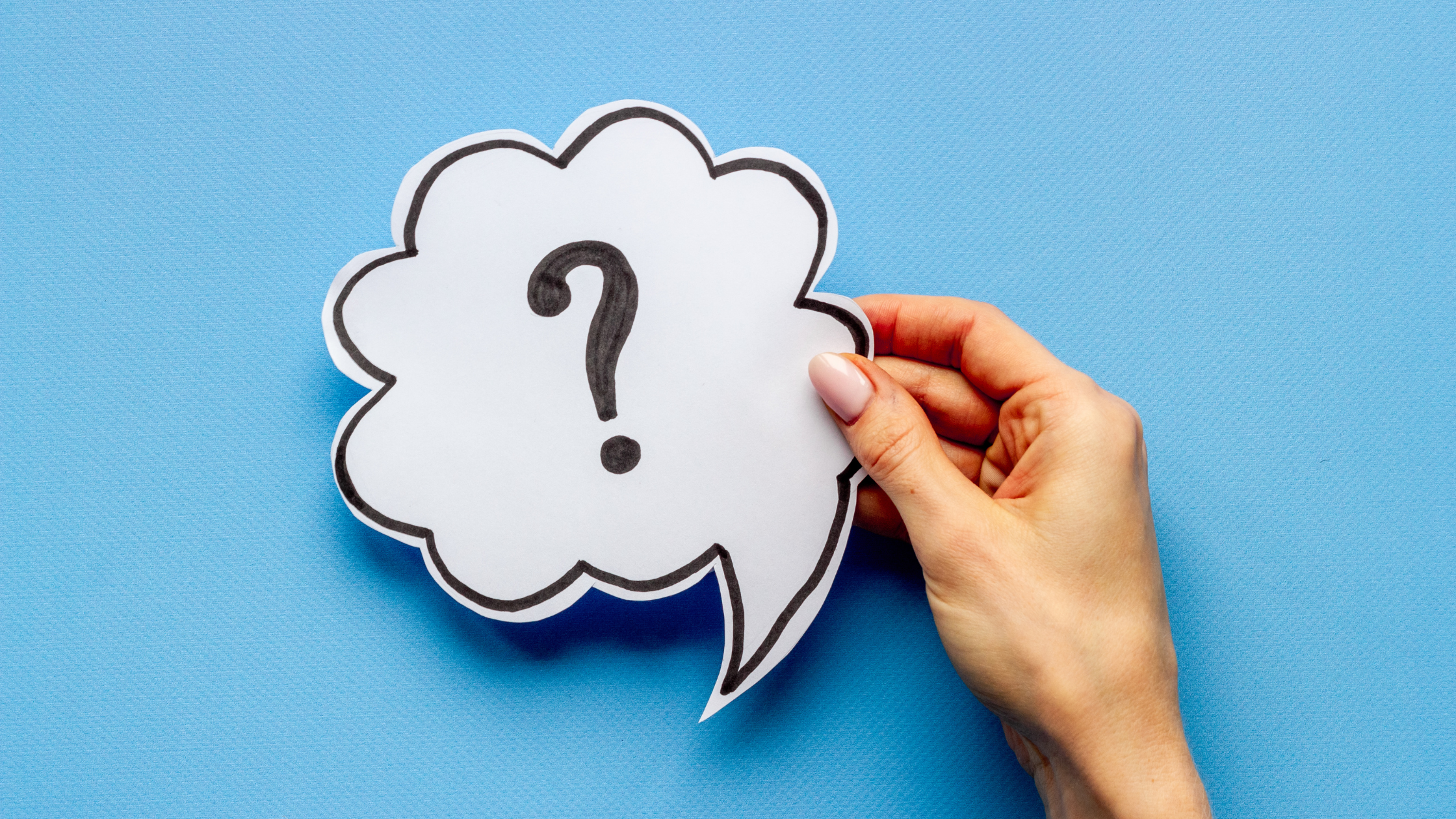 Hand holding question mark cutout, representing how to choose the right Victoria small business phone service.