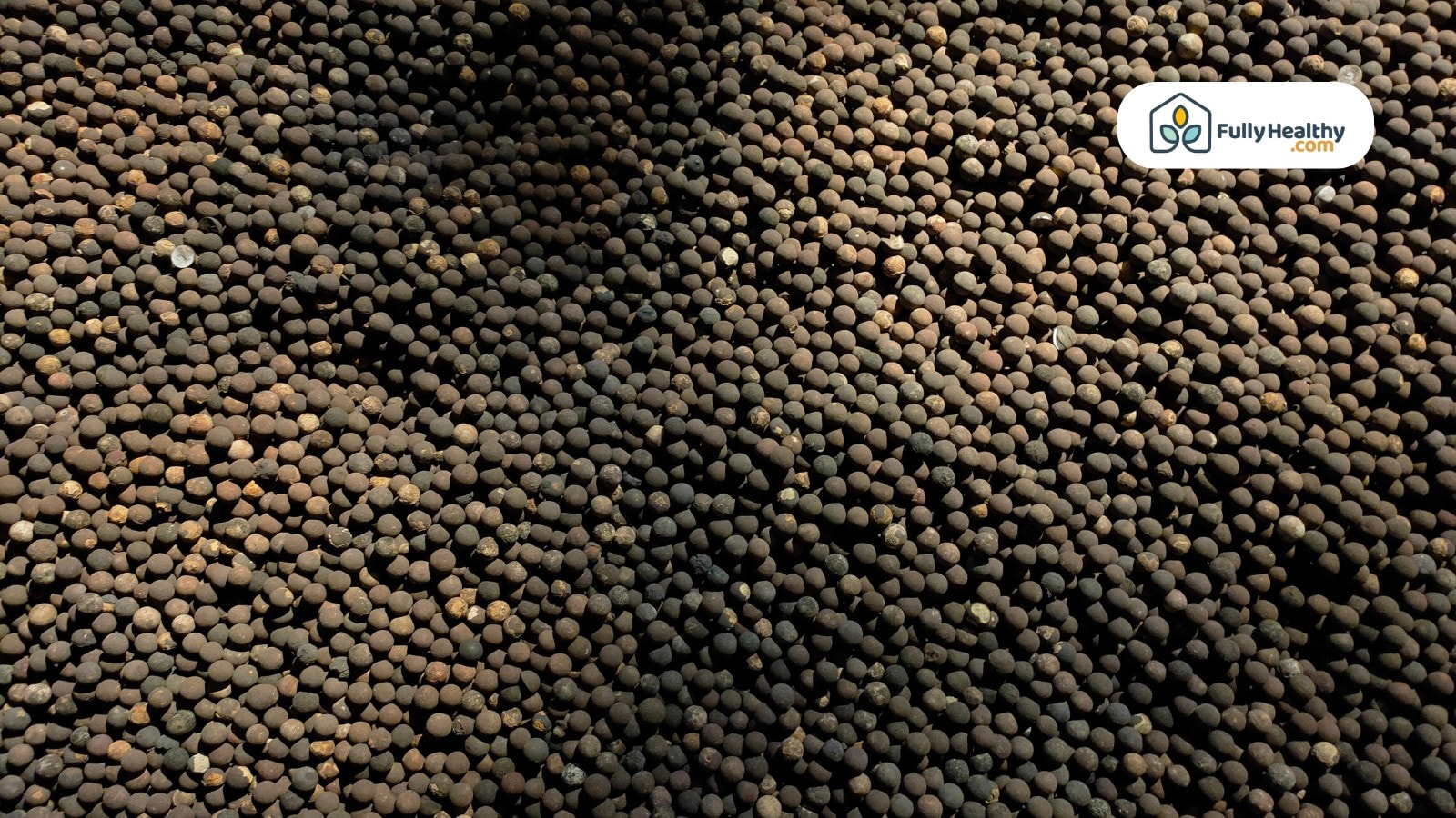Pile of black peppercorns with small white bunny on side