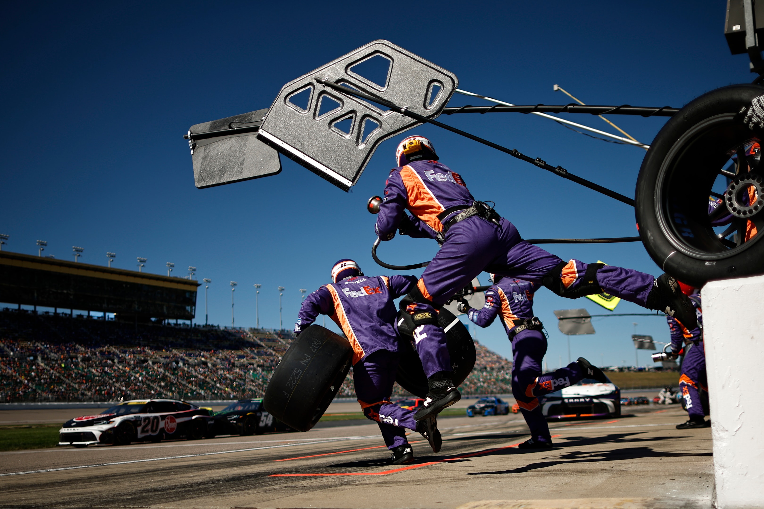 The pit crew of the #11 FedEx Toyota, driven by Denny Hamlin leaps into action during the NASCAR Cup Series Hollywood Casino 400 Presented by ESPN BET at Kansas Speedway on September 29, 2024 in Kansas City, Kansas.