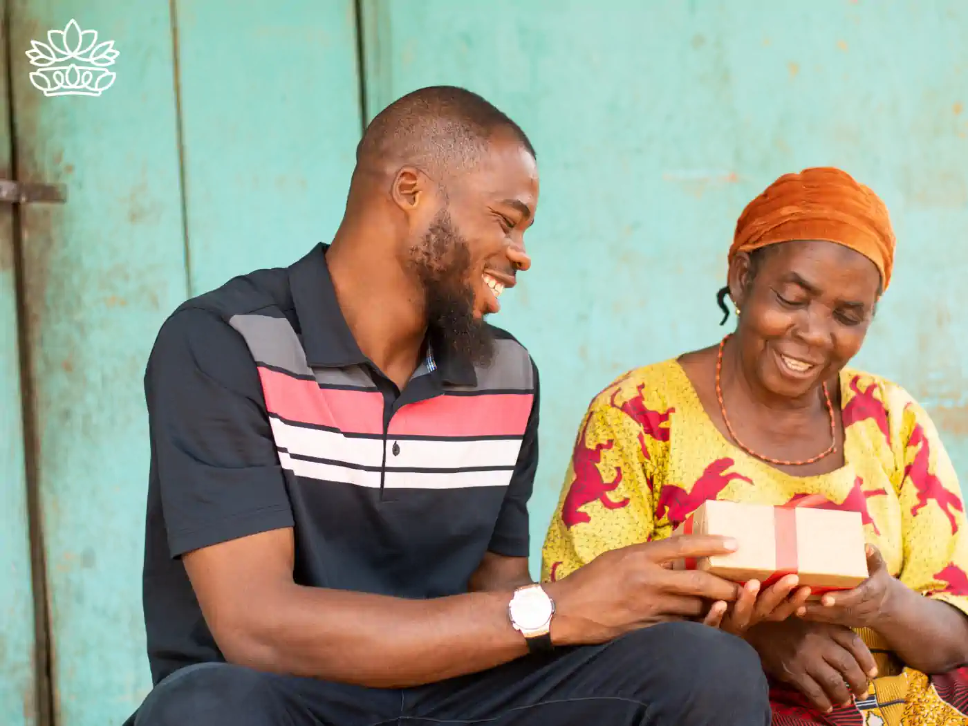 A man giving a luxury gift box to a smiling elderly woman - Fabulous Flowers and Gifts, Luxury Gift Boxes collection.