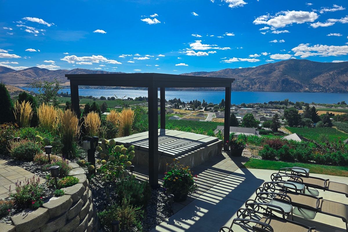 Hot tub pergola installed over a patio, overlooking the water.