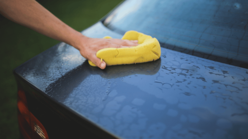 A man is drying the car's surface.