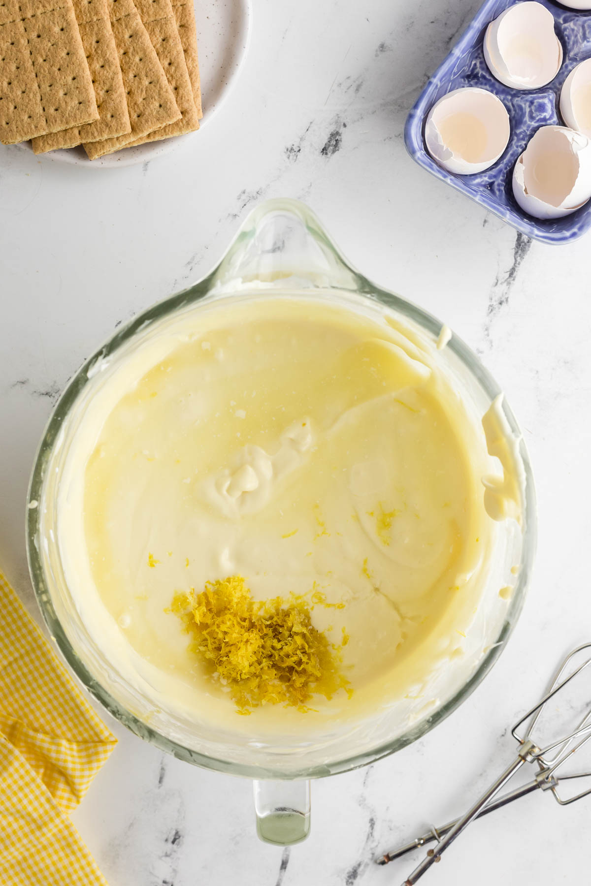 lemon juice and lemon zest added to cheesecake mixture in bowl