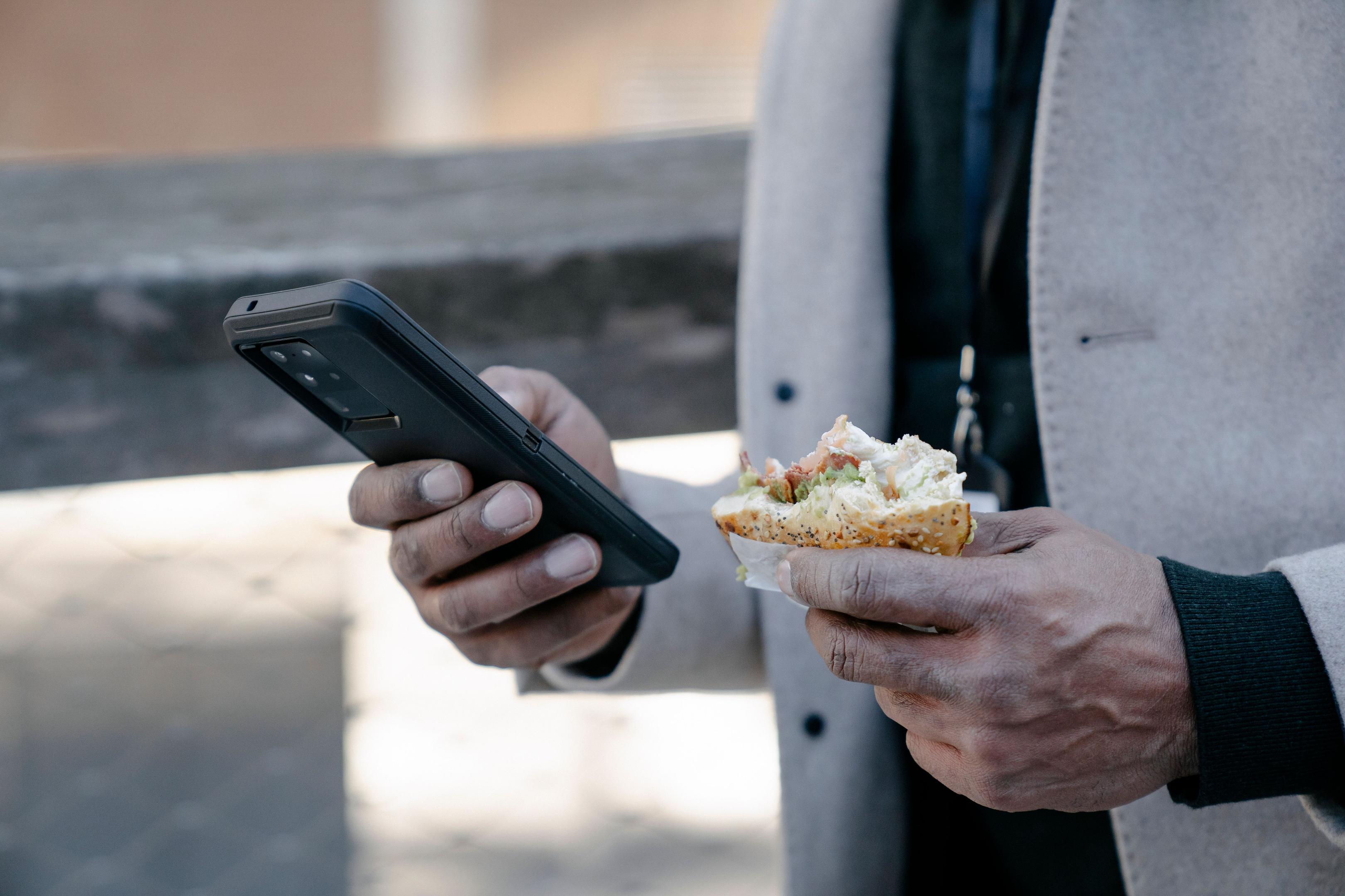 A smartphone is placed on a restaurant counter alongside a receipt and takeout containers, illustrating the integration of voice AI technology in the ordering process.