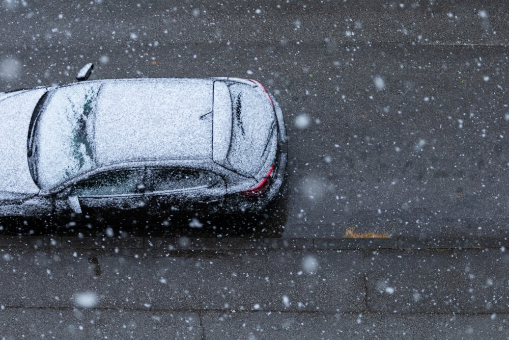 Freepik.com, @wirestock | Zaśnieżone auto na śliskiej , oblodzonej jezdni.