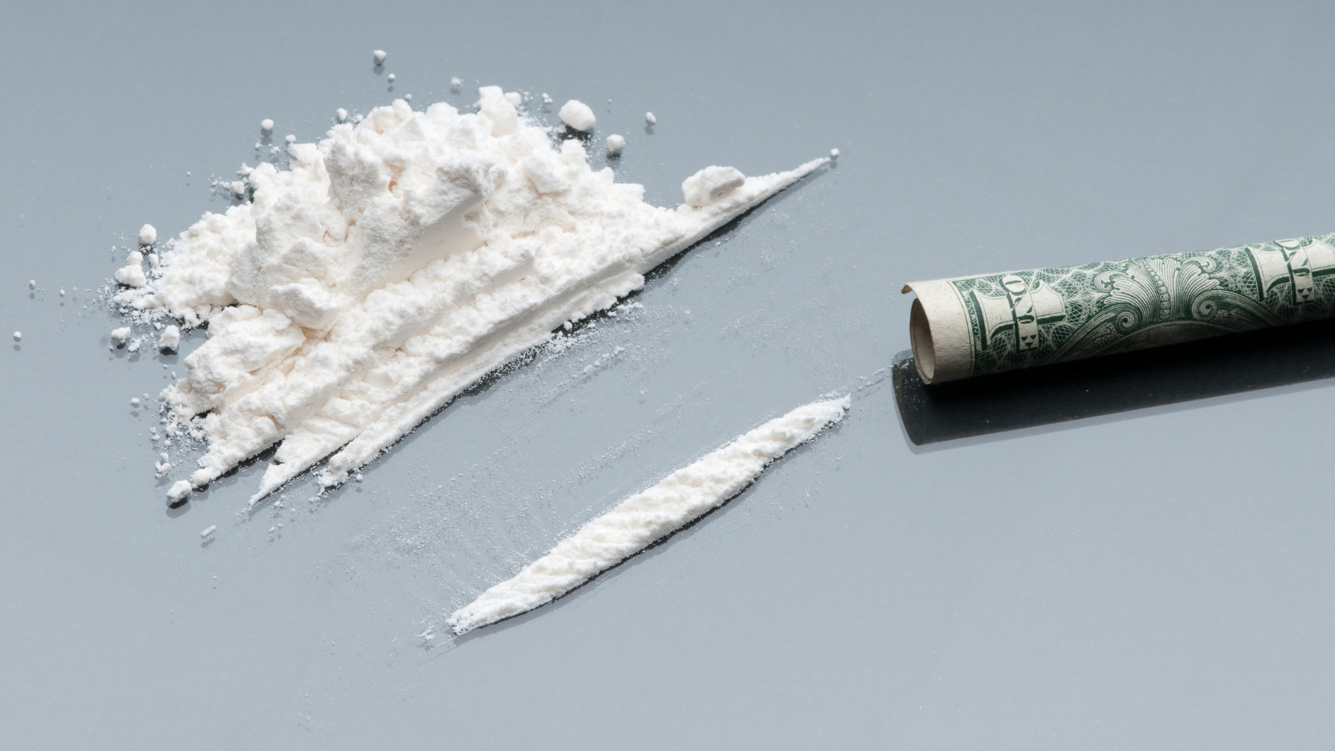 pile of cocaine with a rolled up dollar note