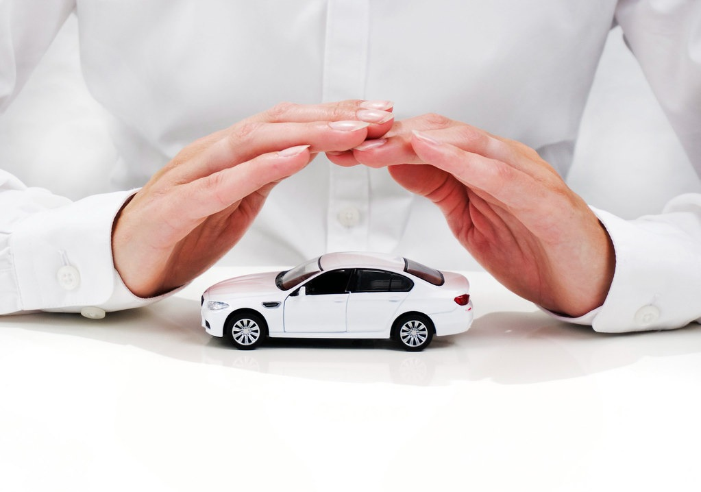 Hands covering a white toy car
