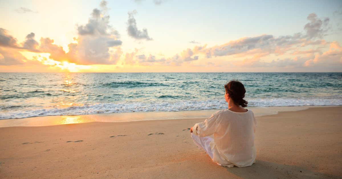 Person sitting on the beach in Avalon, New Jersey watching a peaceful ocean sunset along the Jersey Shore