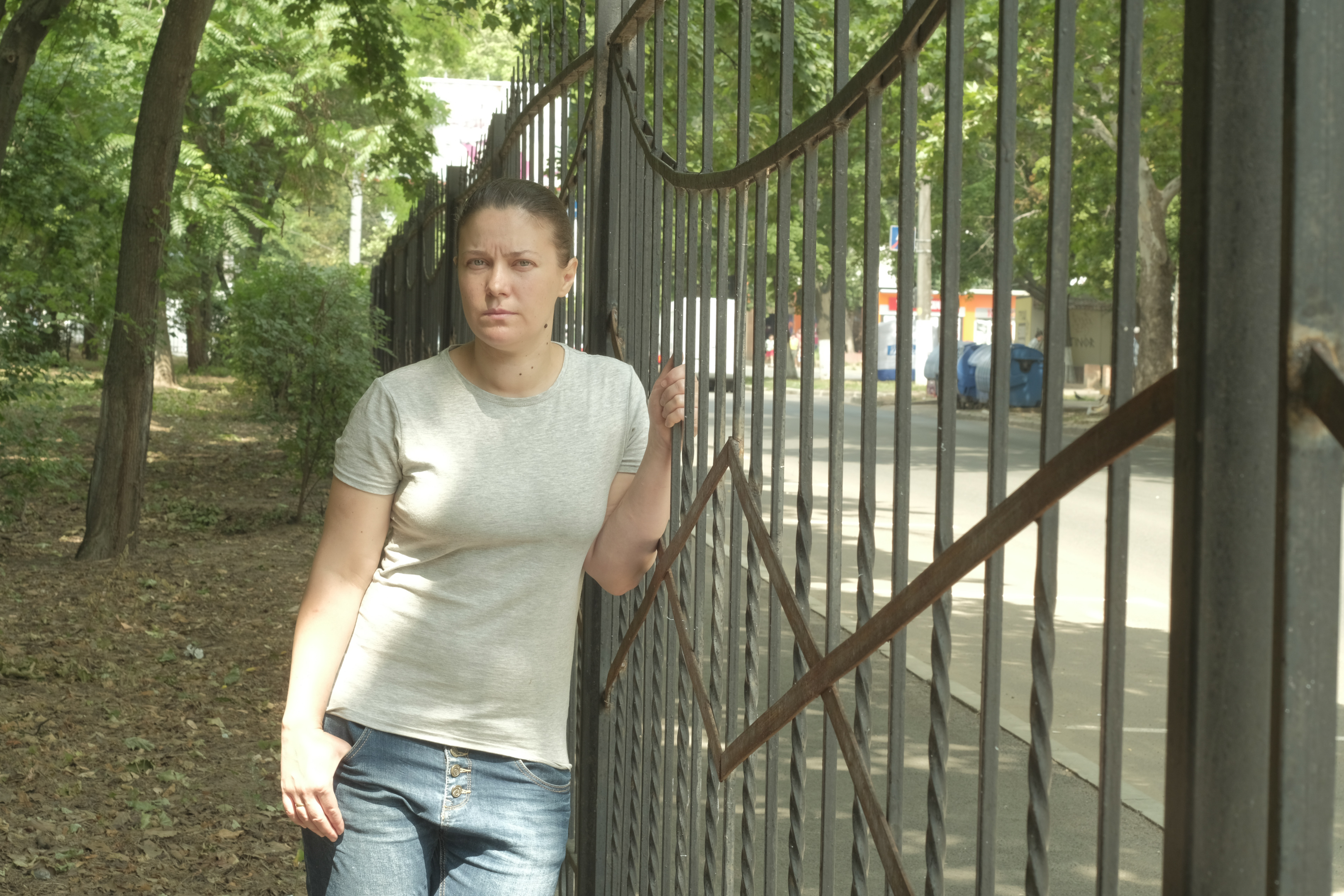 Woman leans against railings in park