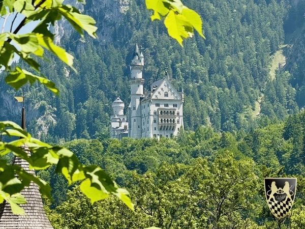 Neuschwanstein Tour Private Driver from Munich 14 A group of tourists stands on the Marienbrücke bridge, capturing photos of the iconic Neuschwanstein Castle, surrounded by breathtaking landscapes. The scene reflects a memorable private day trip experience, showcasing the stunning views and rich history of Bavaria.