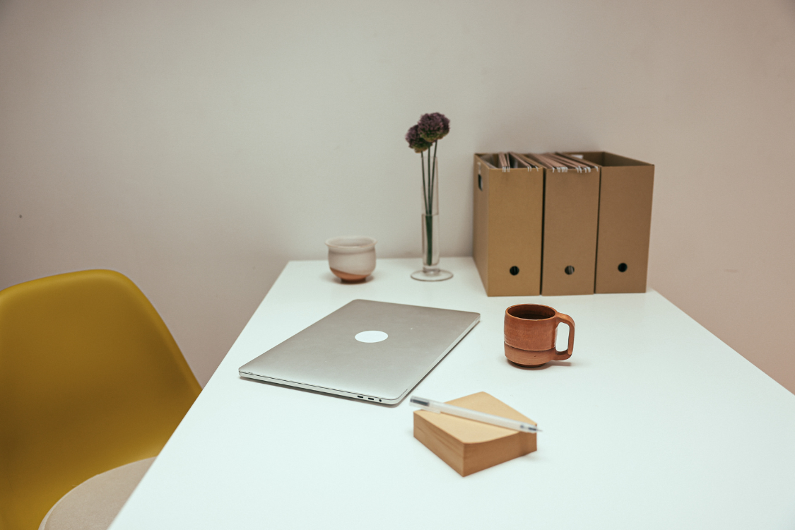 Clean and minimal remote workstation setup with laptop and office supplies.