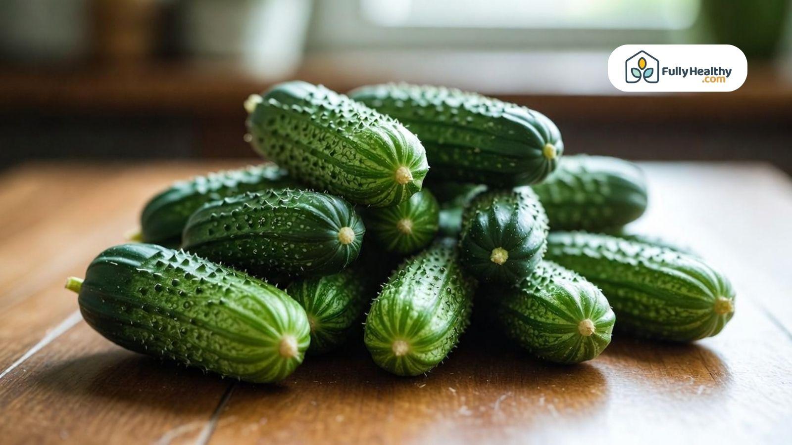 Fresh mini cucumbers stacked on a wooden table.