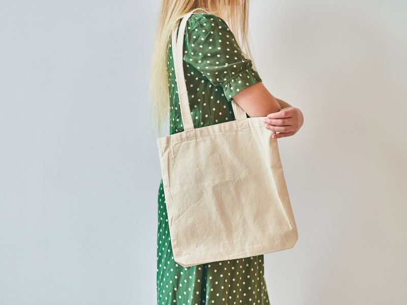 An illustration of a girl carrying a tote bag. 