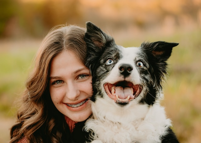 Woman And A Black And White Dog Smiling