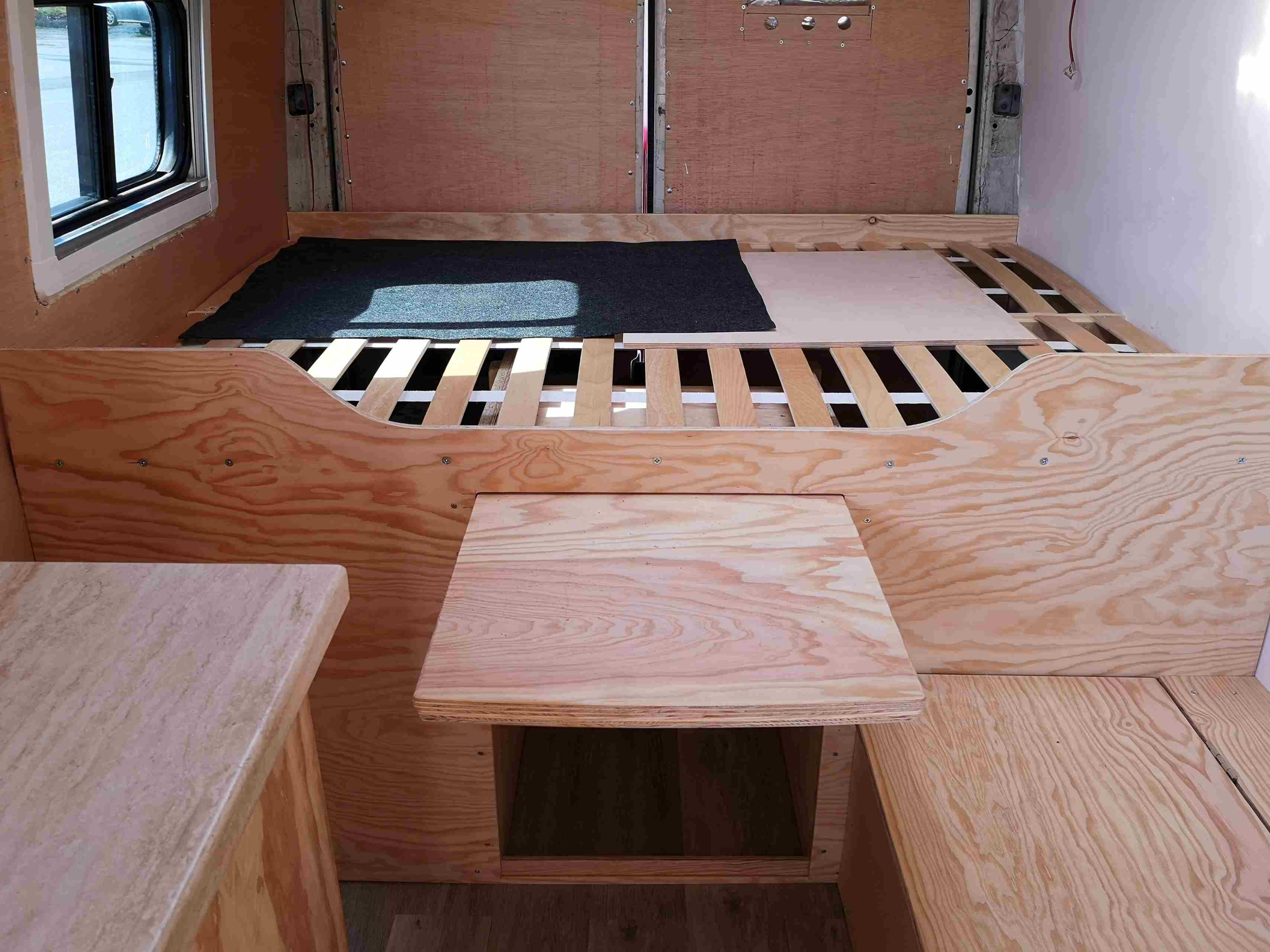 Cama de madeira auto-construída numa carrinha de campismo