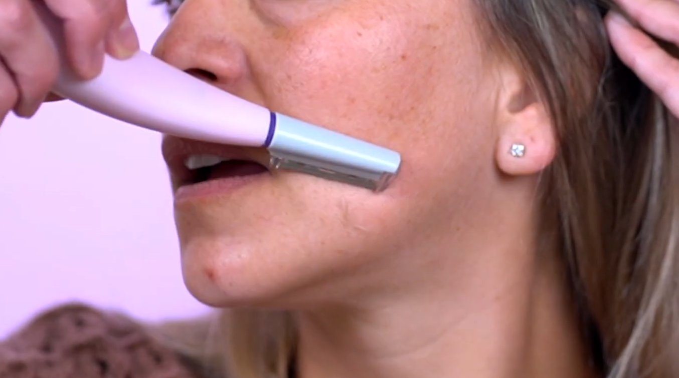 removing all the peach fuzz on the cheek of the woman