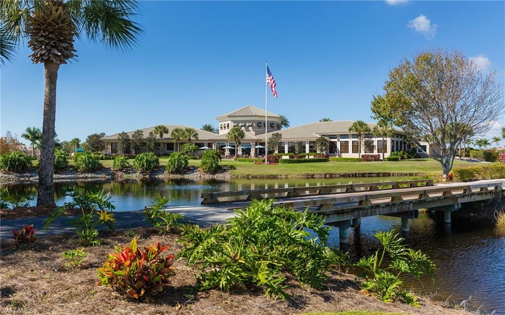 The image depicts the elegant entrance of the Crown Colony community in Fort Myers, featuring lush tropical landscaping and a stylish gatehouse that welcomes residents and visitors. This serene setting highlights the community's appeal, making it a desirable location for prospective properties consumers interested in Crown Colony real estate.