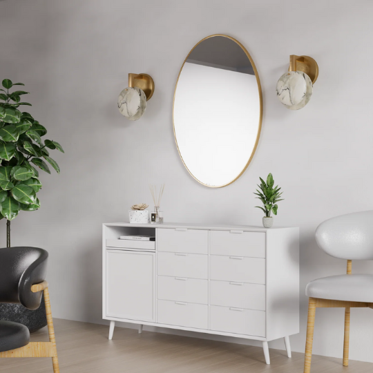 Modern living room setup with marble wall sconces, gold oval mirror, white sideboard, and minimalist decor accents.