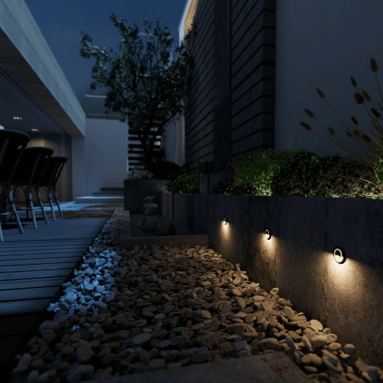 Recessed step lights illuminating a stone pathway, enhancing the modern outdoor space with subtle lighting along the garden's edge.
