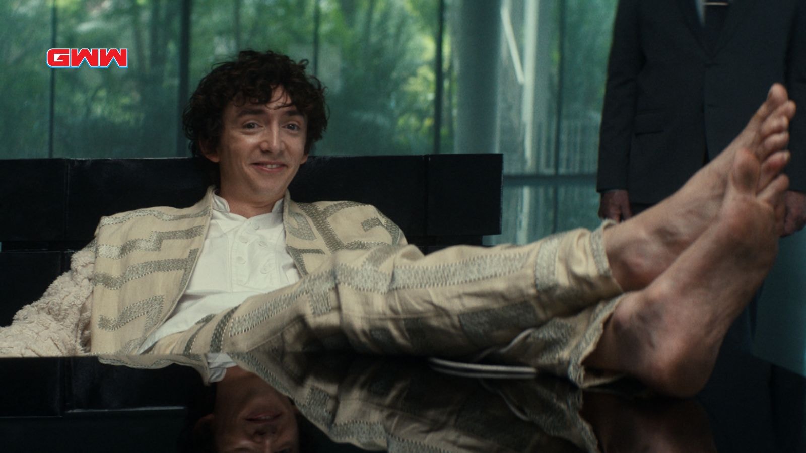 Samuel Blenkin as Boy Kavalier with feet on top of table in Alien: Earth
