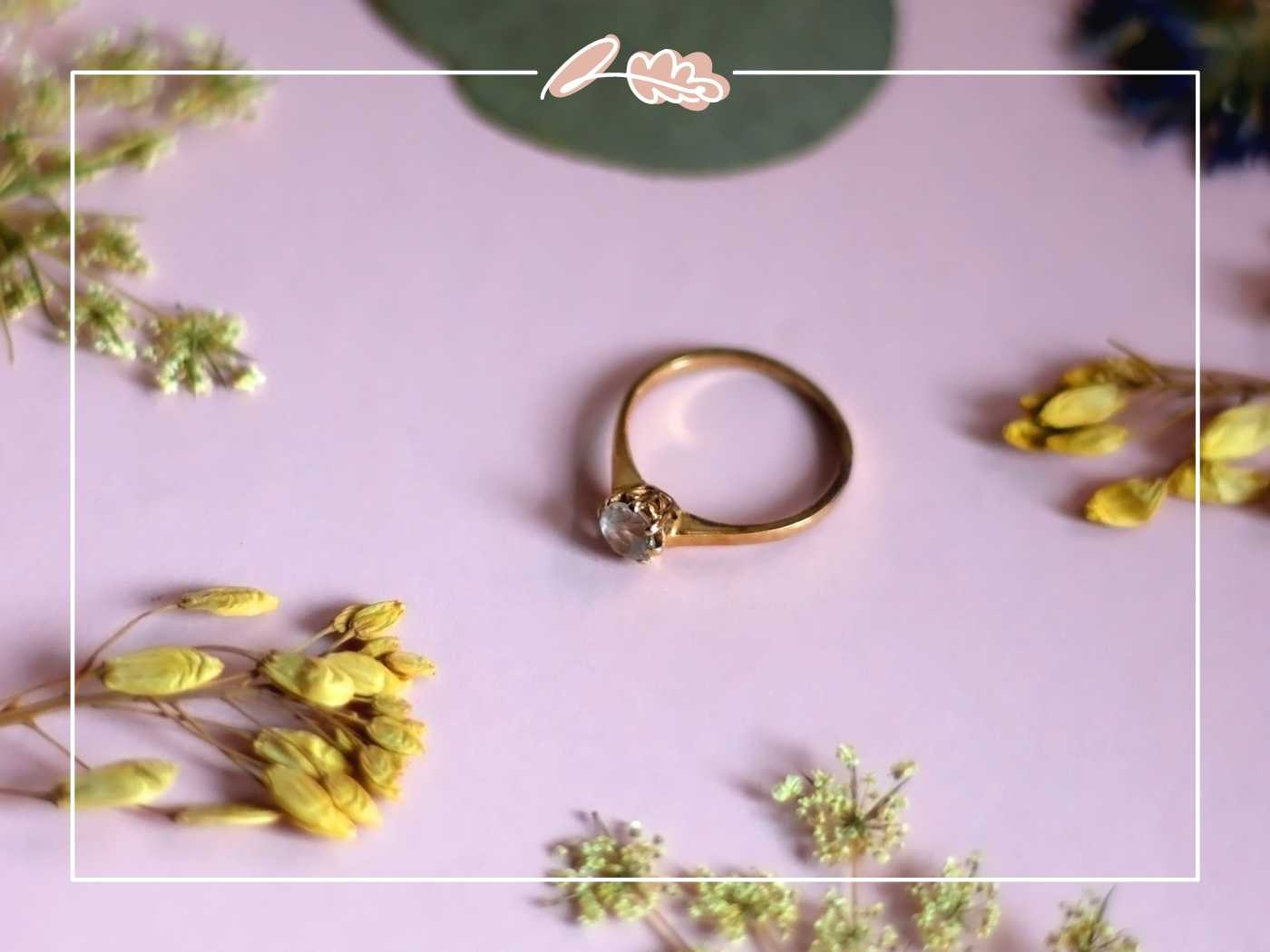 Gold ring on a pink surface with dried flowers - Fabulous Flowers and Gifts