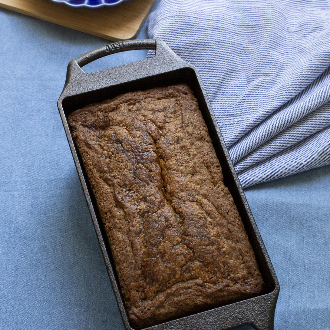 A cast iron pan with a loaf of perfectly cooked bread.