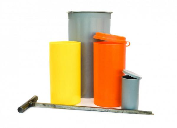 A concrete test cylinder mold with accessories and tools