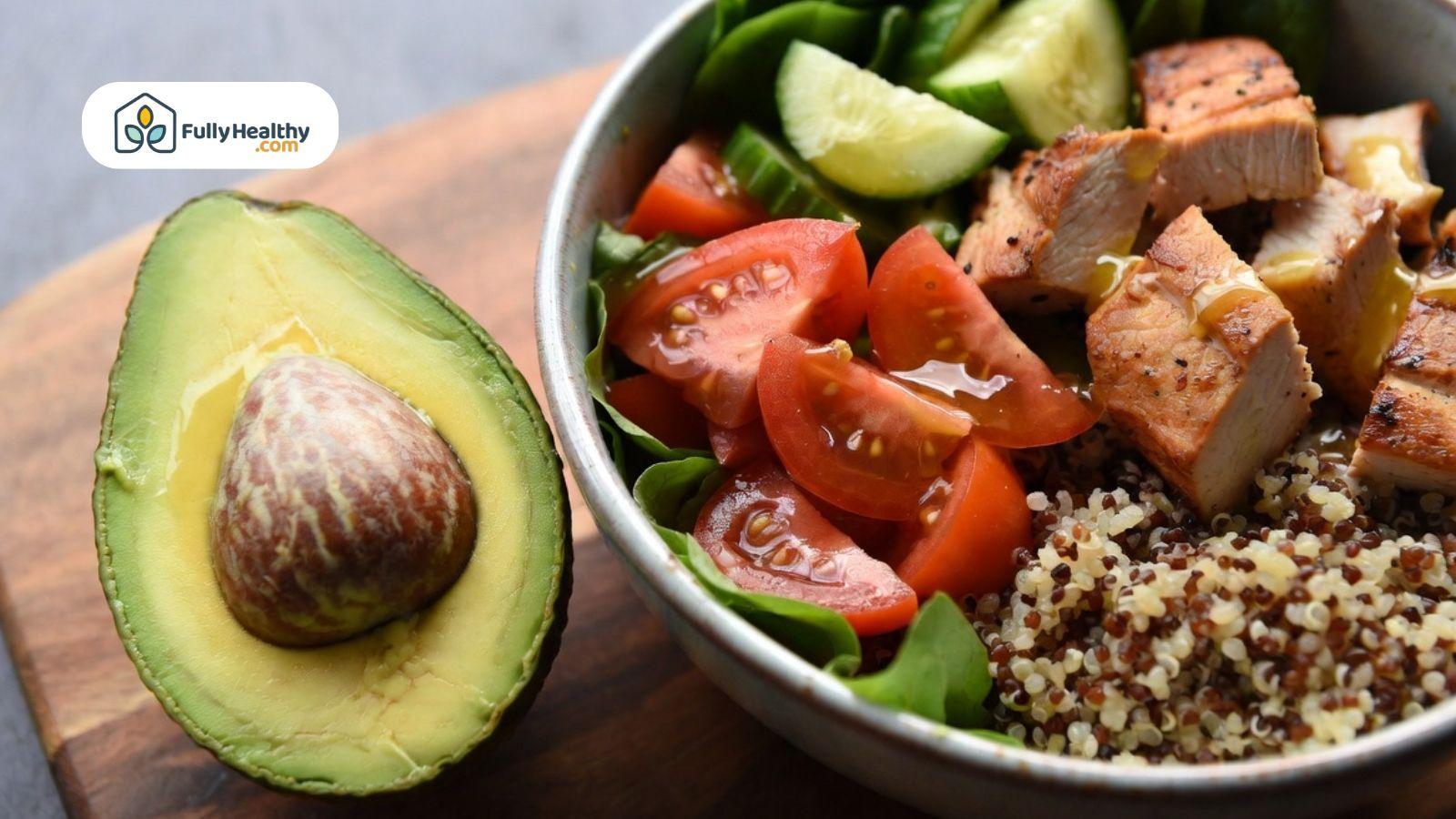 Healthy quinoa bowl with avocado, chicken, tomatoes, and cucumbers.