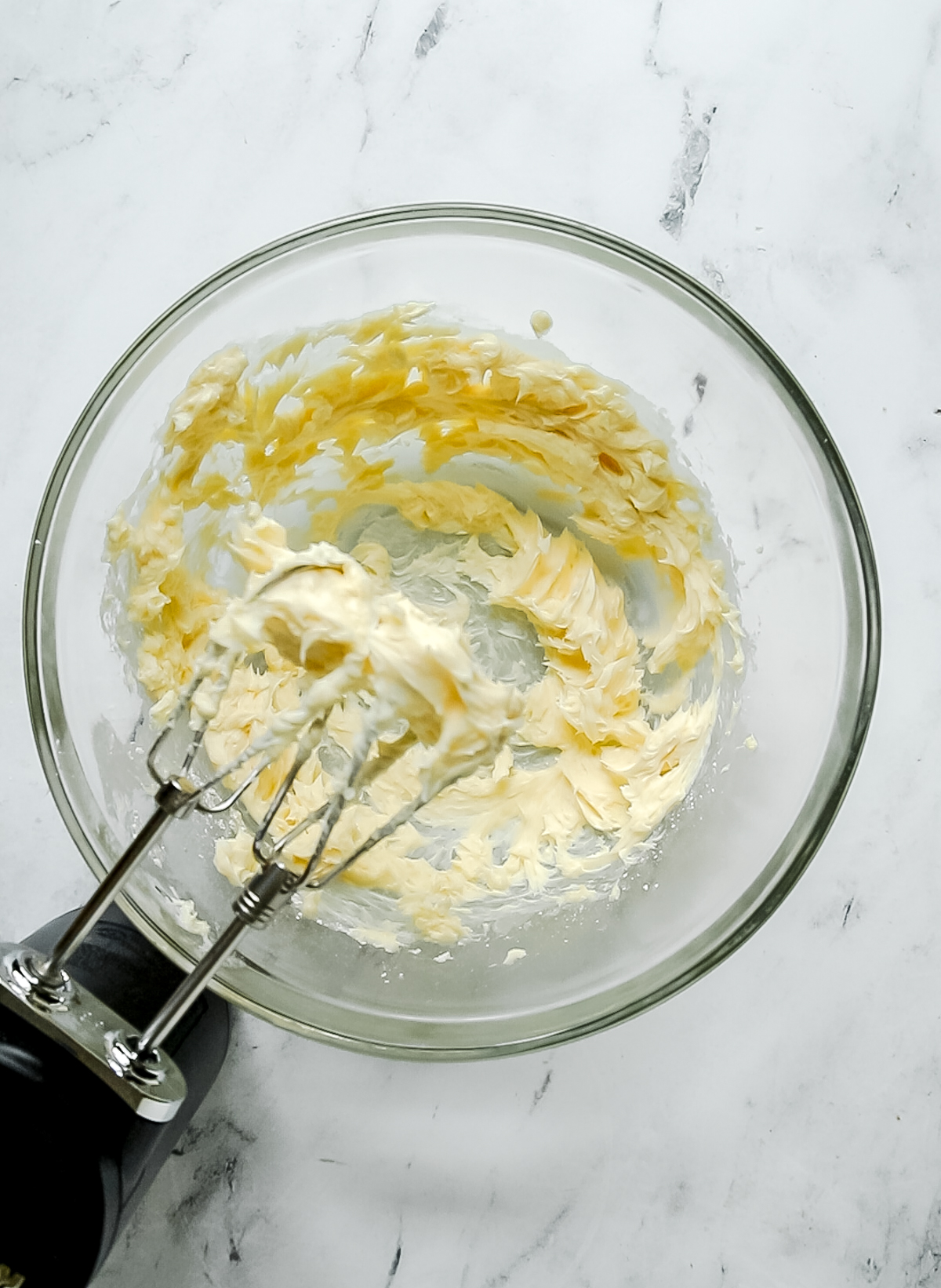 butter, powdered sugar, and vanilla creamed together in bowl with a hand mixer