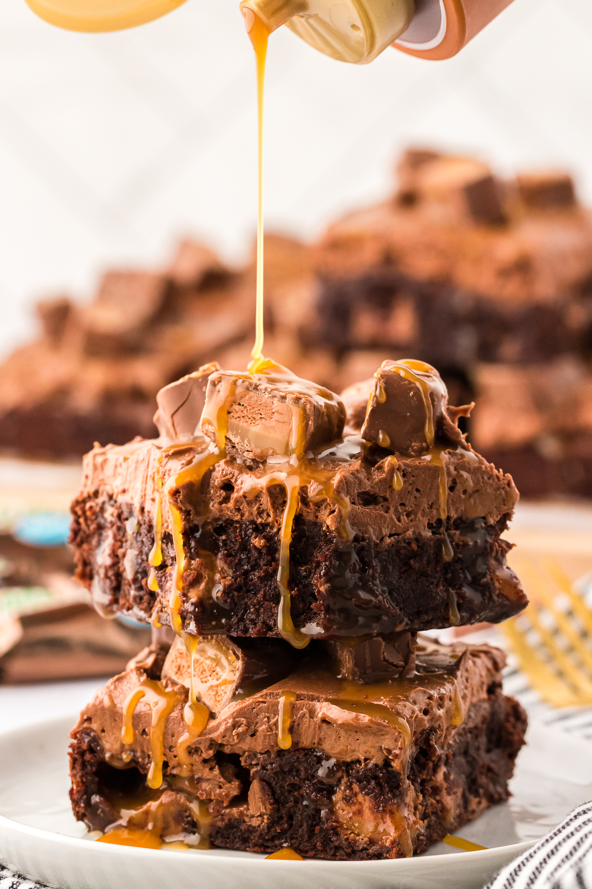 two stacked Milky Way brownies with caramel drizzled on top