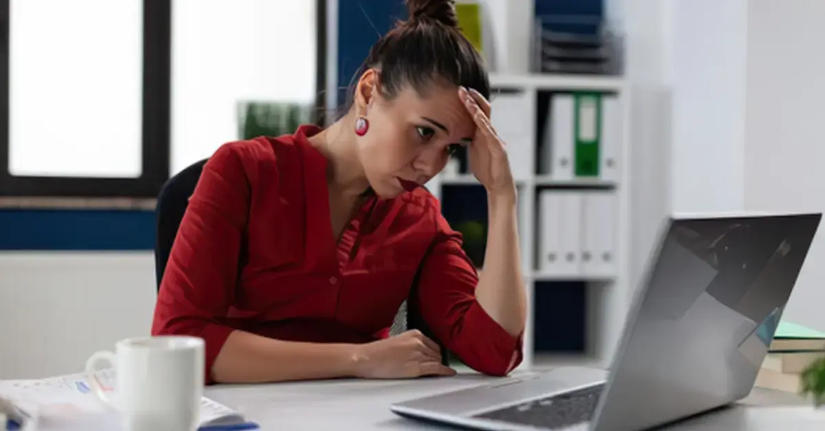 Woman reviewing an IRS tax levy notice and financial records at her home office.