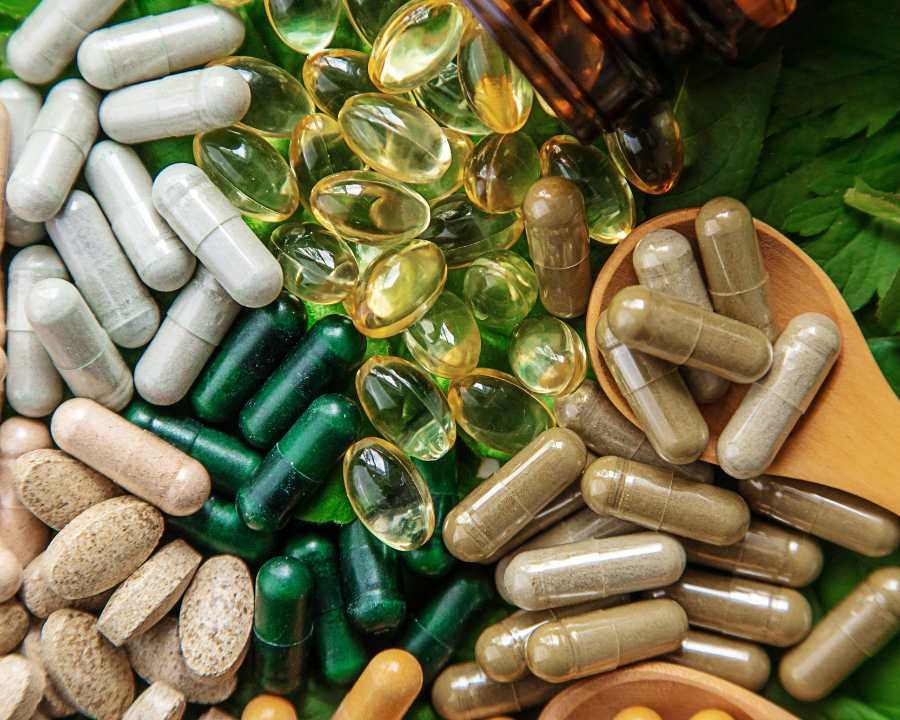 In the image, various dietary supplements, including vitamin C, vitamin D, calcium, and fish oil, are neatly arranged on a wooden surface, highlighting the importance of vitamins and minerals for health and nutrition. These vitamin and mineral supplements are essential for supporting the immune system and overall well-being.