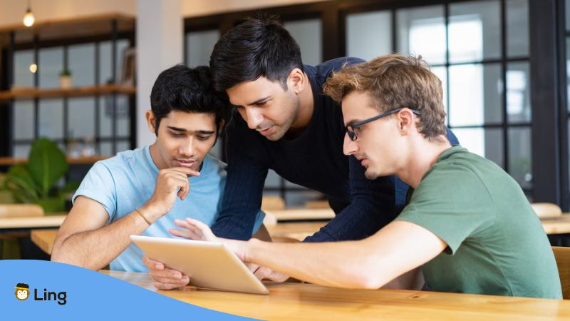 A photo of native speakers teaching a language learner how to learn Malayalam fast with language learning apps.