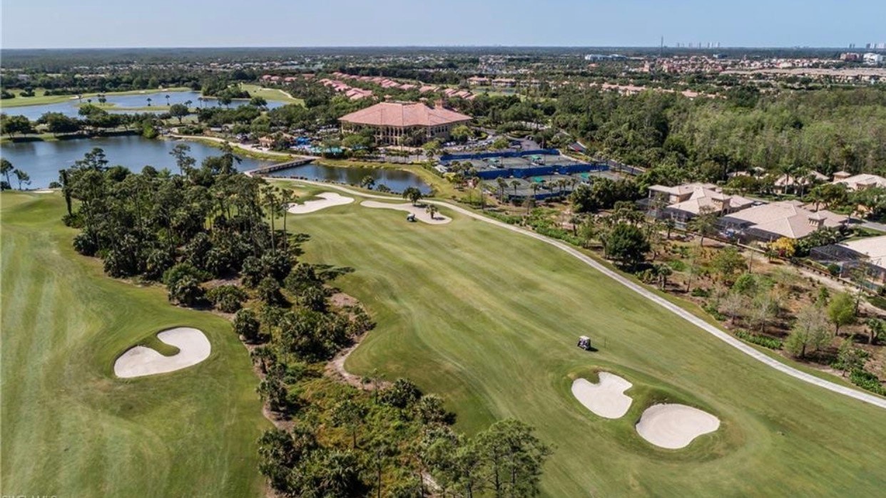 The image depicts a luxurious swimming pool area featuring spa facilities and elegant lounging spaces, perfect for relaxation and social gatherings in a gated community in Estero, FL. Surrounded by beautiful landscaping, this inviting area serves as a focal point for residents and guests, offering convenient access to nearby amenities like the Grandezza golf course and fitness center.