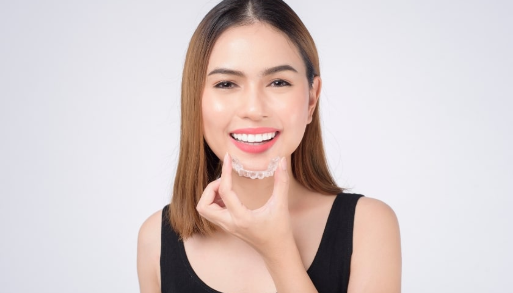 Kvinne smiler og holder en gjennomsiktig tannregulering foran munnen for å rette tennene diskret. usynlig tannregulering koster usynlig tannregulering behandling med usynlig tannregulering tennene dine usynlig regulering typer usynlig tannregulering tannregulering dine tenner usynlig baksiden av tennene gjennomsiktige skinner voksne pasienter mellomrom mellom tennene blant annet tennene typen regulering mindre synlig bak tennene bruke skinnene siste årene usynlige tannreguleringer invisalign ønsket resultat pusser tennene nye skinner tenner regulering behandling behandlingen skinner voksne 20 år 22 timer aligner skinnene usynlige pris konsultasjon mer rette hos bruke mindre barn våre typer andre får tannlege tannlegen prisen smil ofte gjennomsiktige behov ønsker derfor flere måneder litt vanlig incognito finnes tannleger helfo kjeveortoped tilbyr ulike gjør spark rett blant skinne tid brukes støtte behandlingstid refusjon dag måte