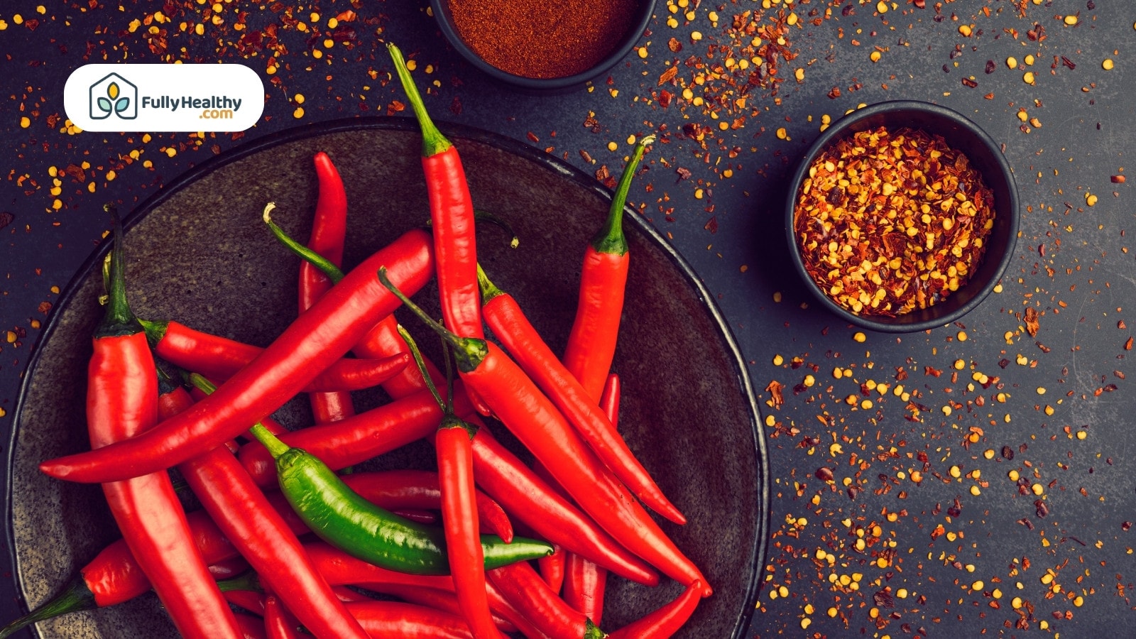 Red and green chilies with bowls of crushed pepper and powder