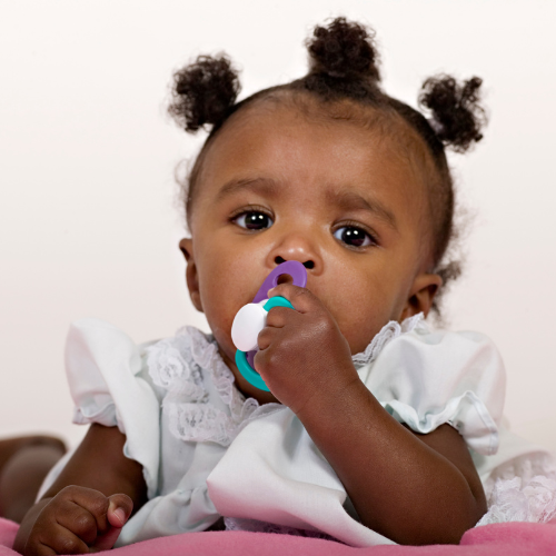 little girl in pigtails with dummy