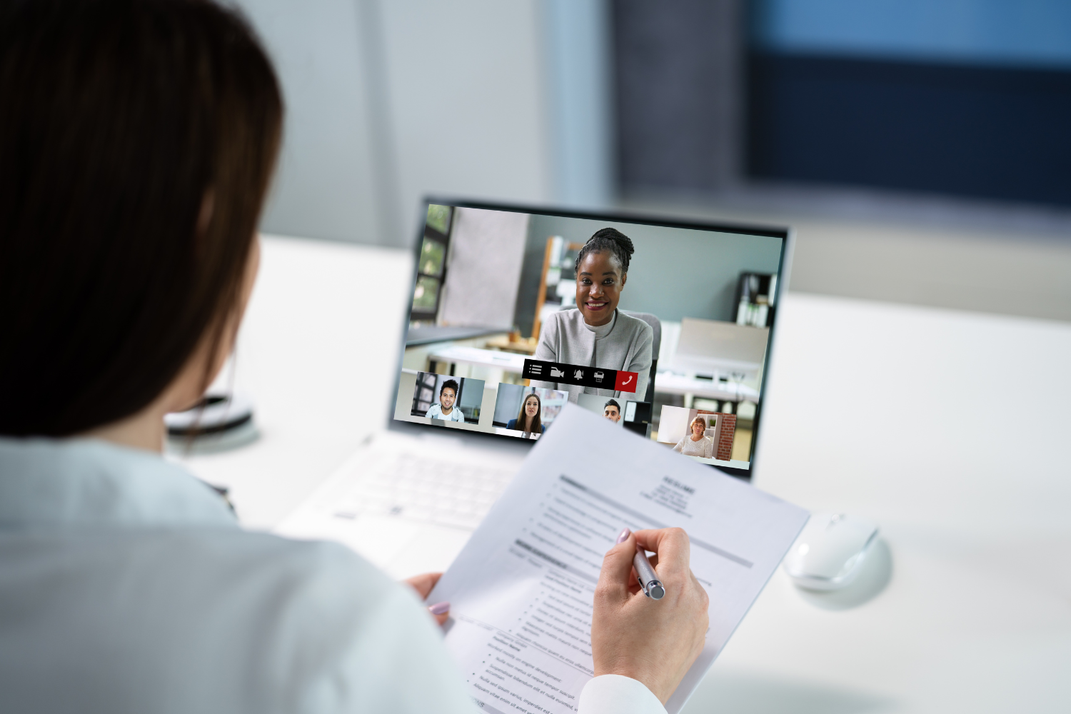 A manager speaking with remote team through video call.