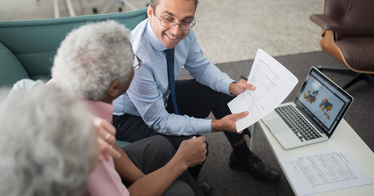 Accountant smiling while assisting a client with paperwork on a laptop, illustrating what is the difference between payroll tax and income tax for OnlyFans creators.