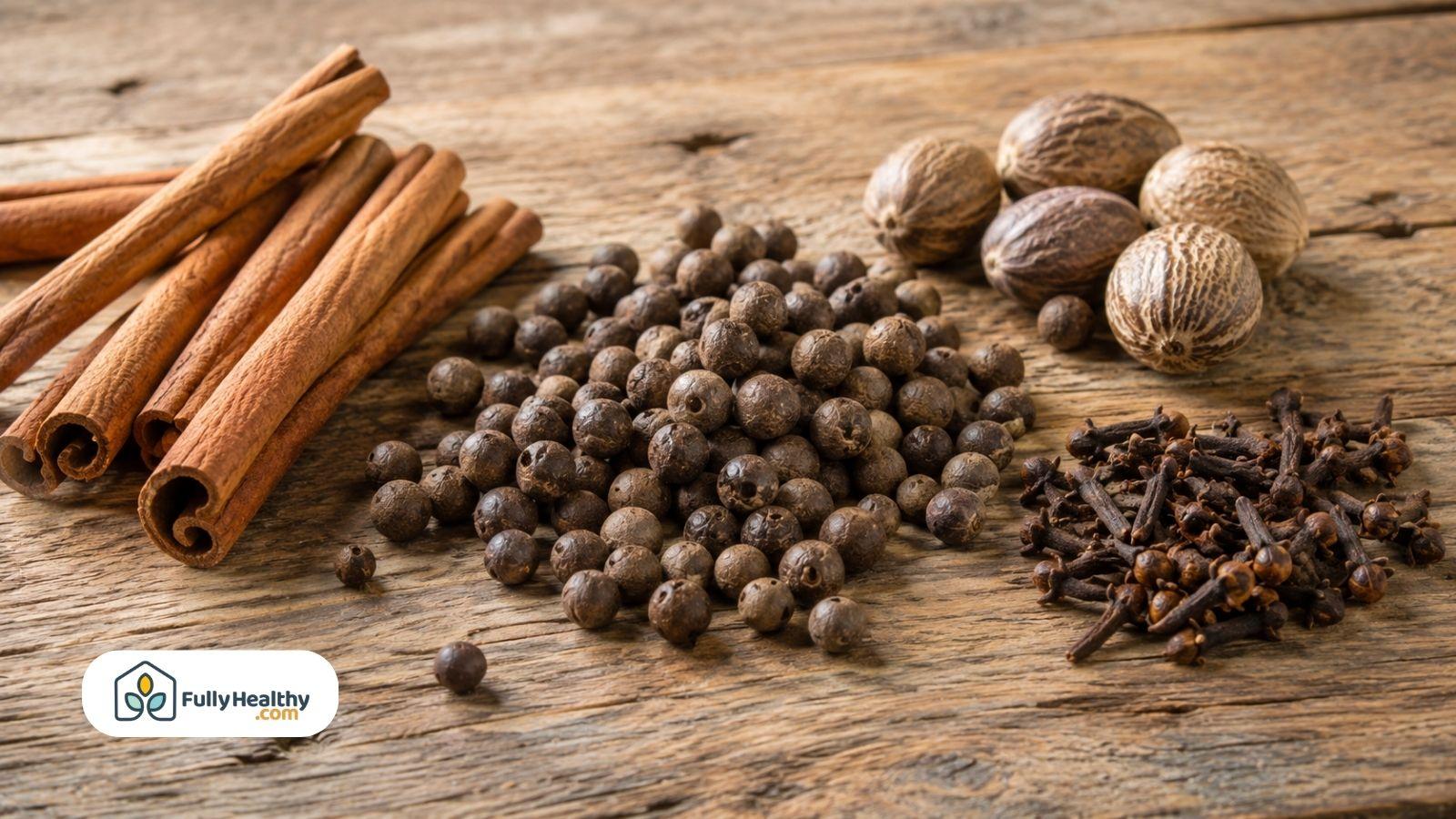 Cinnamon sticks allspice berries nutmeg and cloves on rustic wooden table