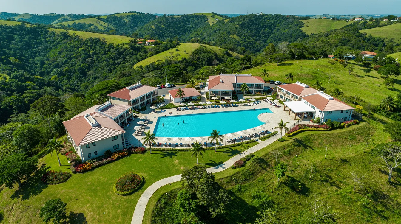 f4cb5728 3e57 4069 8512 bbb52cf0bfb1 An aerial view of a mid-scale resort property is depicted, nestled among lush green hills and featuring a sparkling swimming pool. This image highlights the potential for resort development and the attractiveness of the location for hospitality projects.
