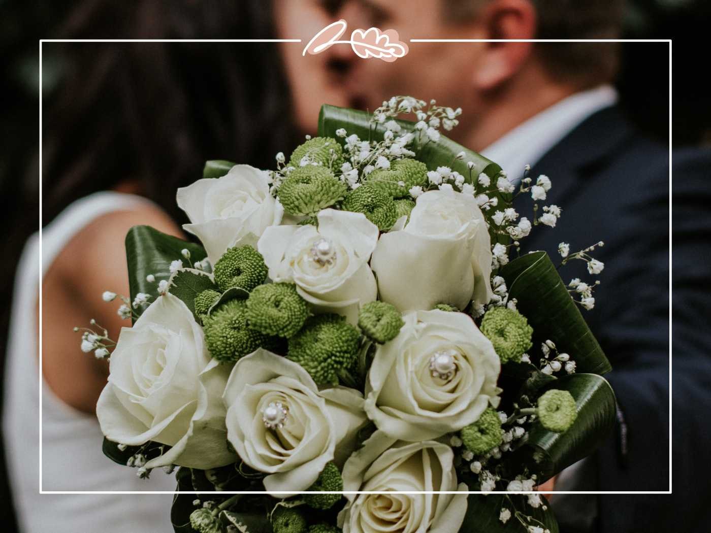 A bride holding a sophisticated bouquet of white roses and green accents, capturing the essence of wedding elegance. Fabulous Flowers and Gifts.