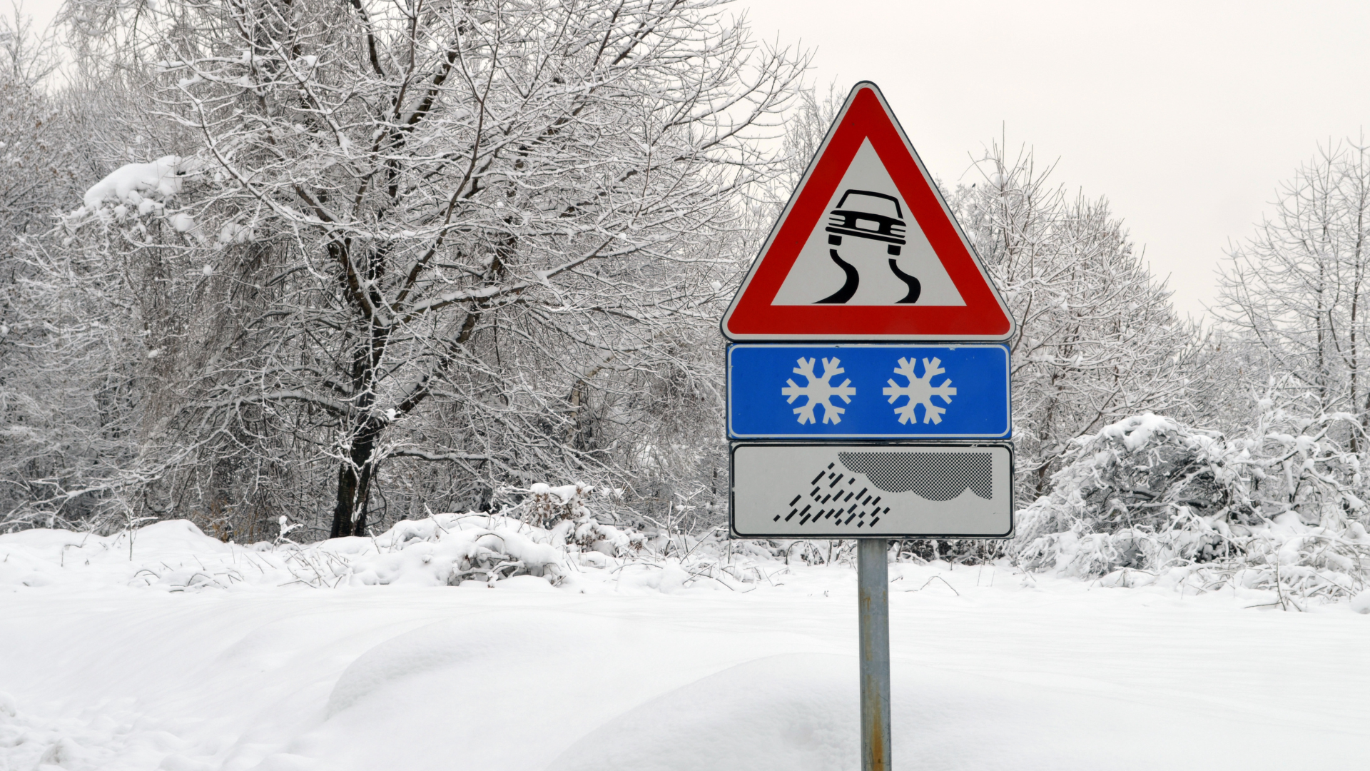 slippery road sign with snow and rain