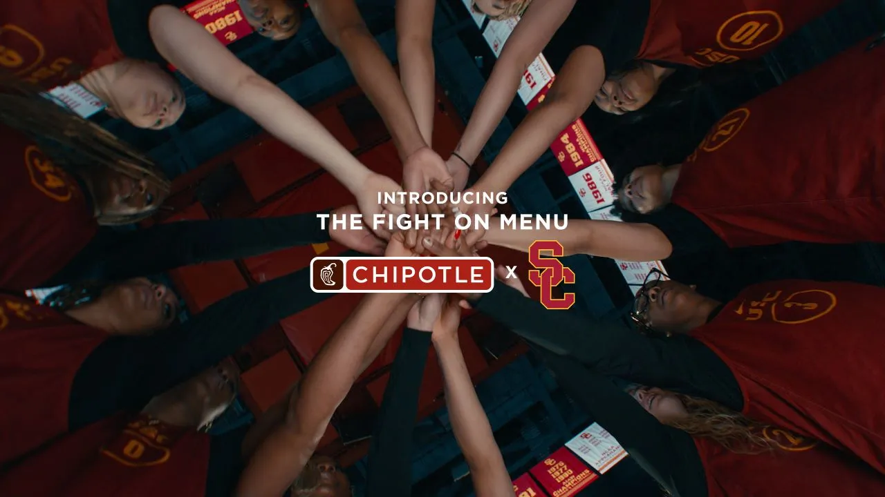 USC women's basketball team huddling hands together under a spotlight as part of their NIL partnership announcement with Chipotle, featuring the 'Fight On Menu' campaign branding.