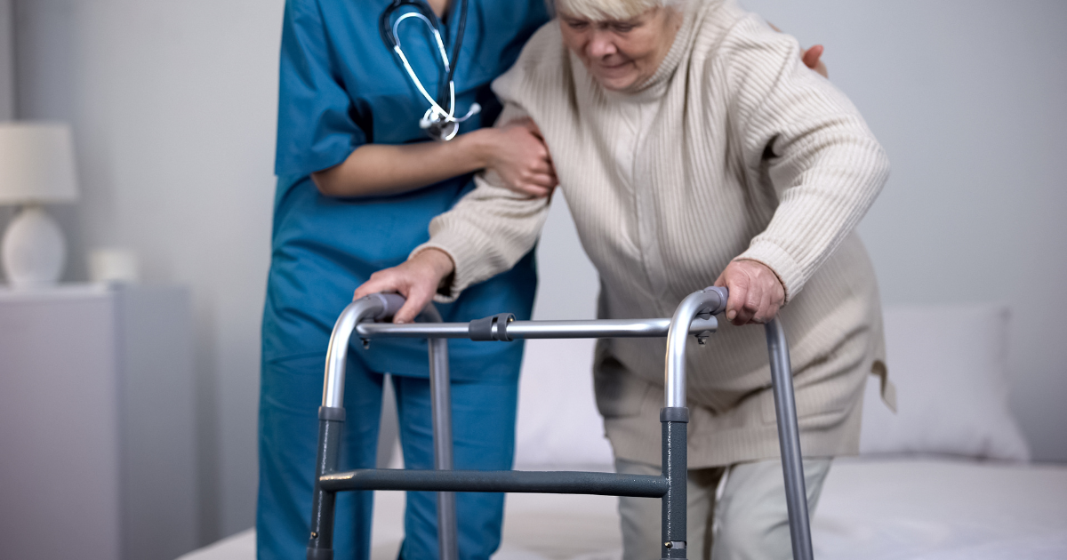 Woman being assisted after hip replacement surgery