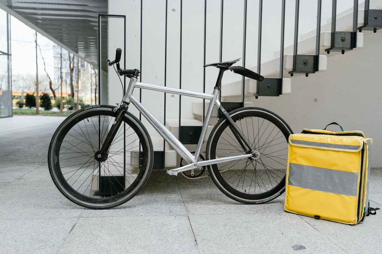 Bicicleta encostada e uma caixa térmica ao lado. Foto: Pexels