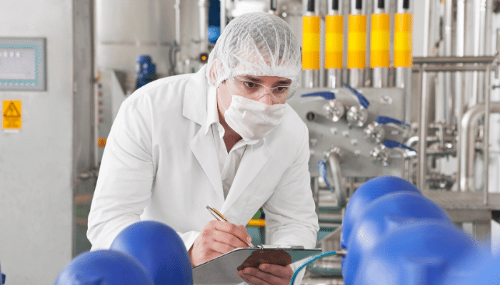 Pharmaceutical manufacturing worker using paper-based systems on the plant floor.